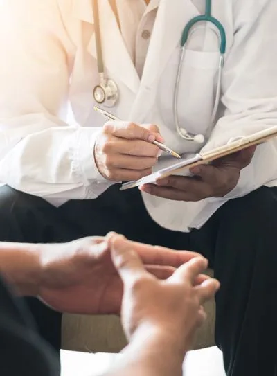 Medical examiner taking notes during a physical